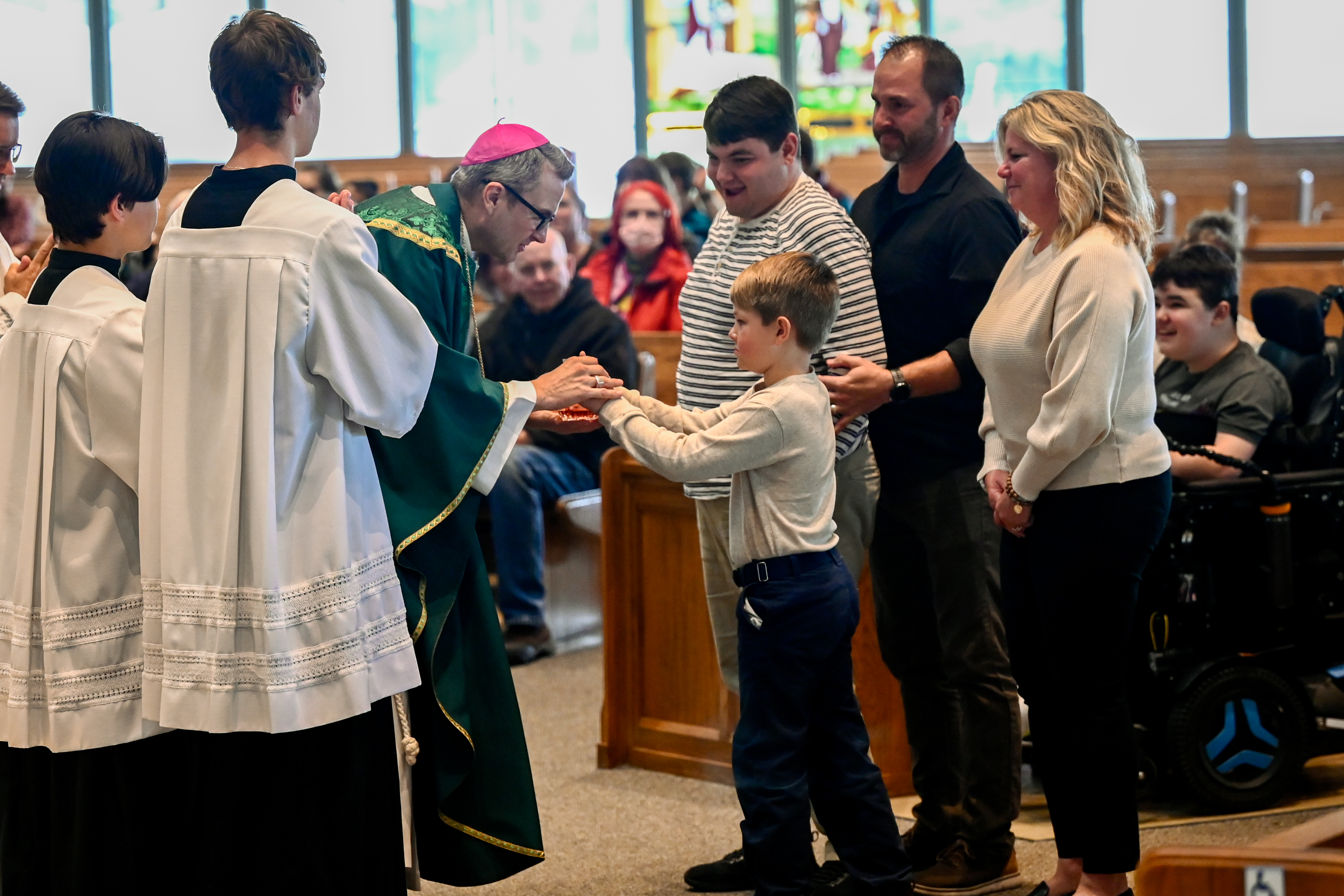 Family bringing up gifts for Bishop Hicks at Mass